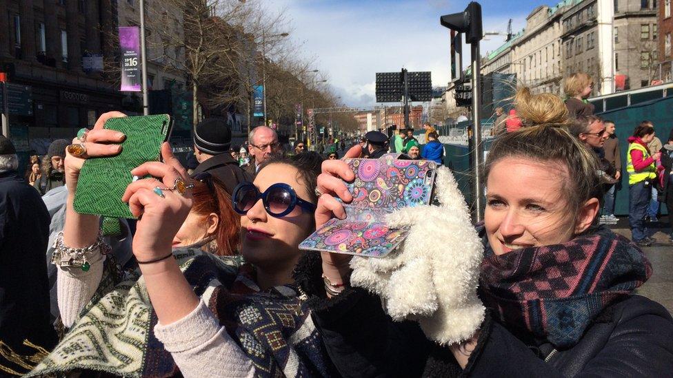 Spectators used 21st Century technology to record the commemorations of events that took place 100 years ago, but they paused in silence during the re-reading of the proclamation of independence