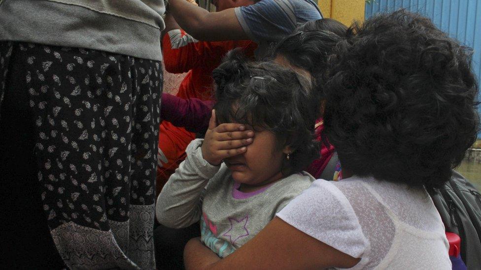 A young flood victim reacts as she sits in a boat after being rescued in Chennai