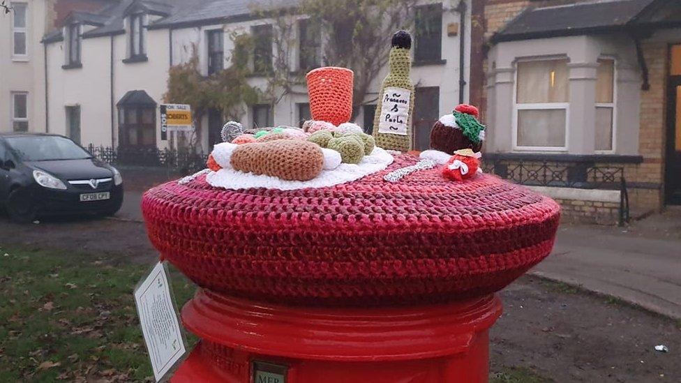 Knitted Christmas hats appear on post boxes in Caerleon - BBC News