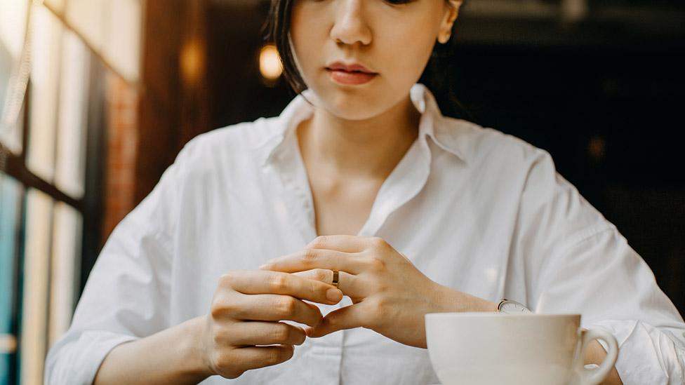 Woman removes wedding ring