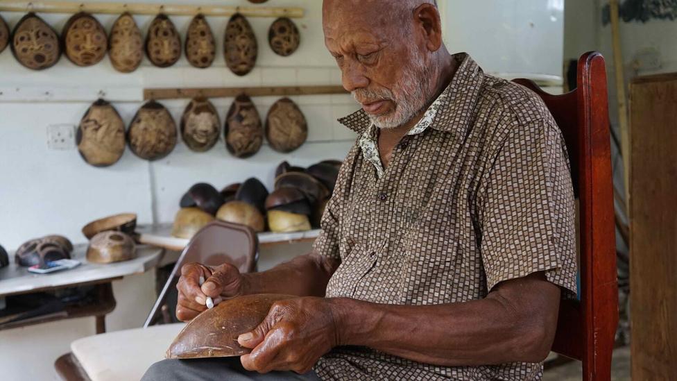 Faustulus Frederick decorating a calabash gourd