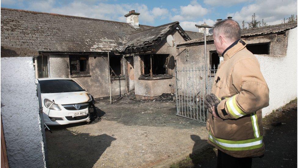 A fireman looks at the damaged house at Greenhaw Avenue