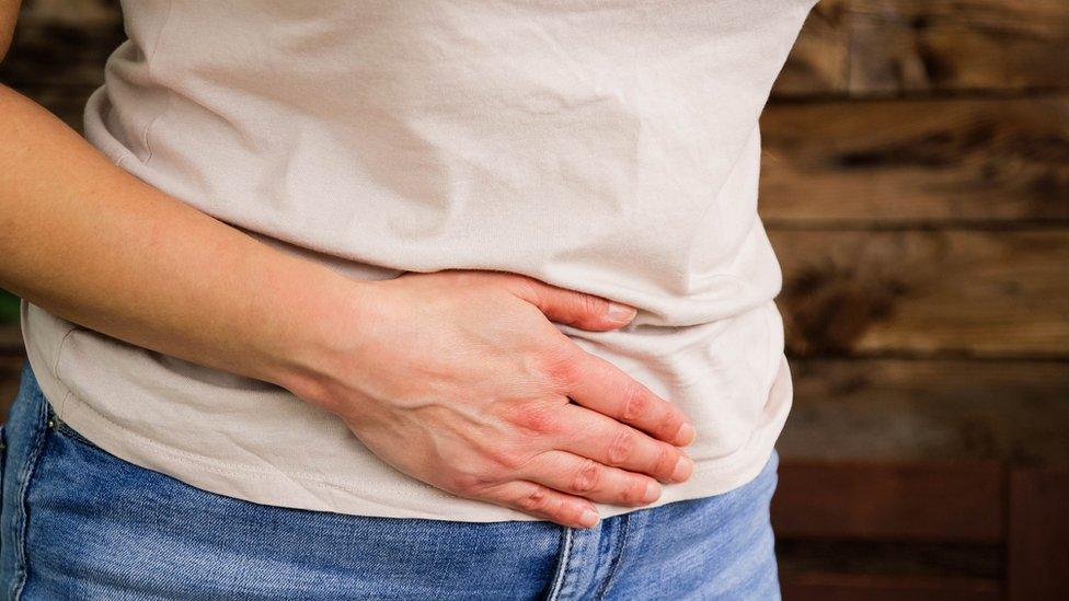 Woman holding lower abdomen