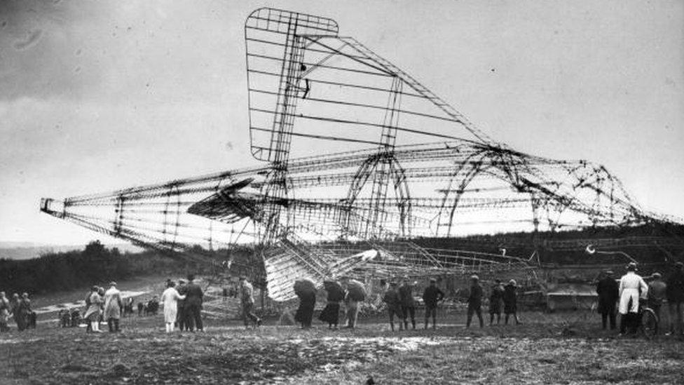 A crowd look at the wreckage of the crashed airship R101 at Beauvais, France