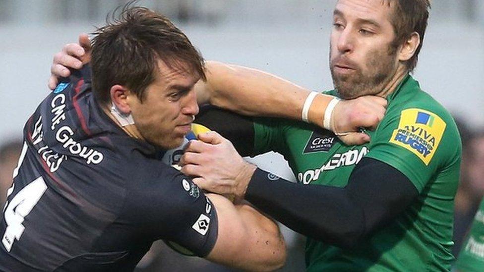 Saracens' Chris Wyles can be seen wearing the device behind his ear as he is tackled by Tomas O'Leary of London Irish