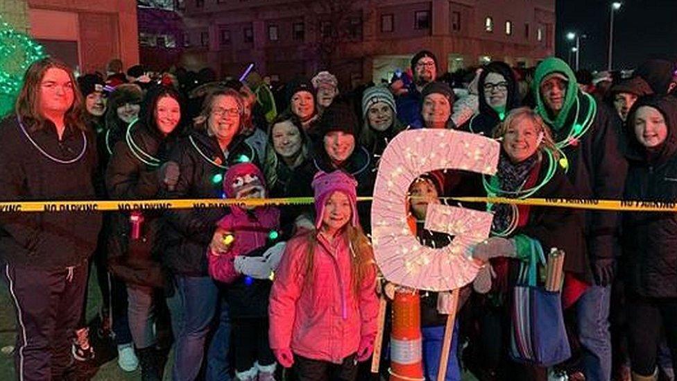 A giant flashing G sign is held up