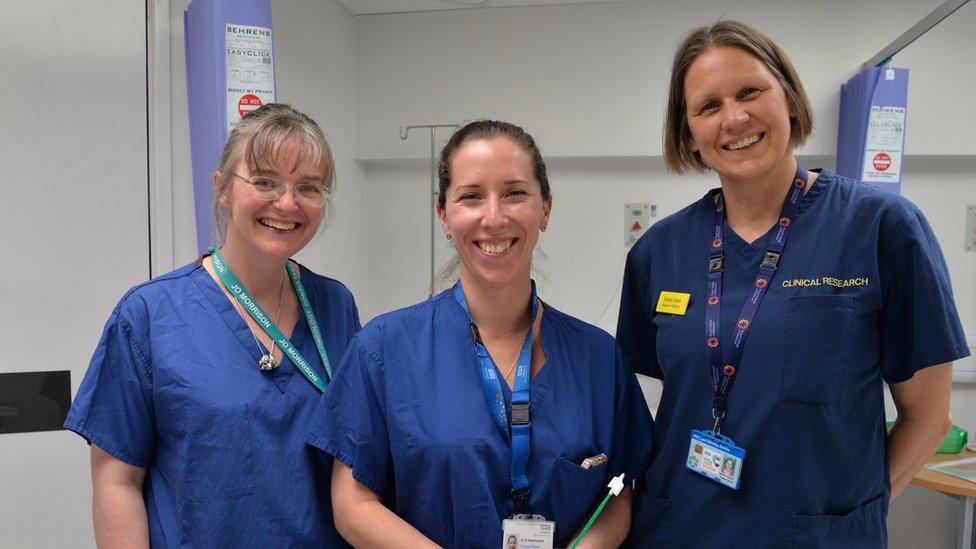 Jo Morrison, Dr Holly Baker-Rand and Dr Becky Newhouse smile at the camera while wearing medical scrubs