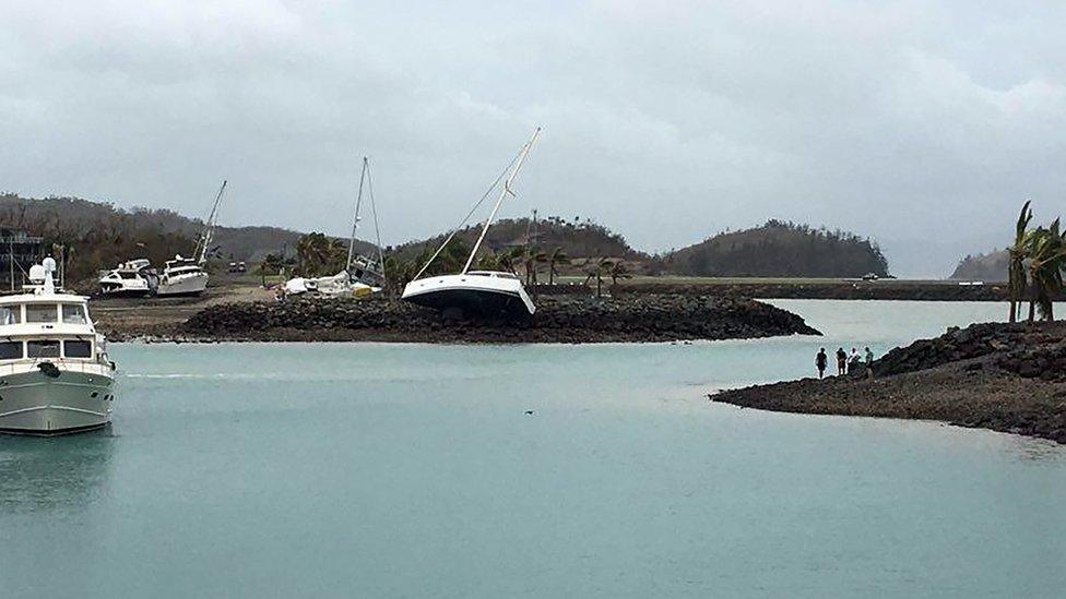 A boat (C) ran aground on Hamilton Island after strong Cyclone Debbie hit the Whitsundays Islands in Queensland on March 29, 2017