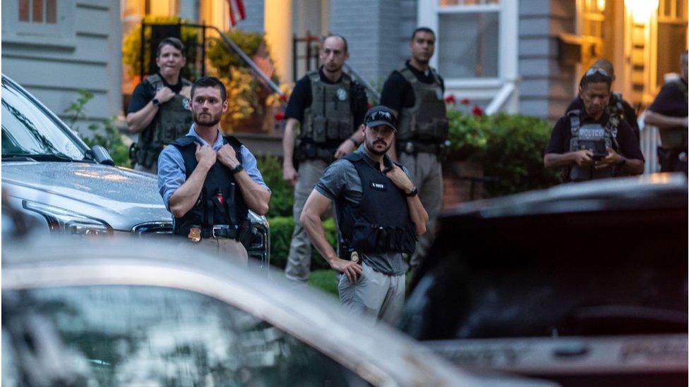 Police oversee protesters gathered outside a judge's home last summer