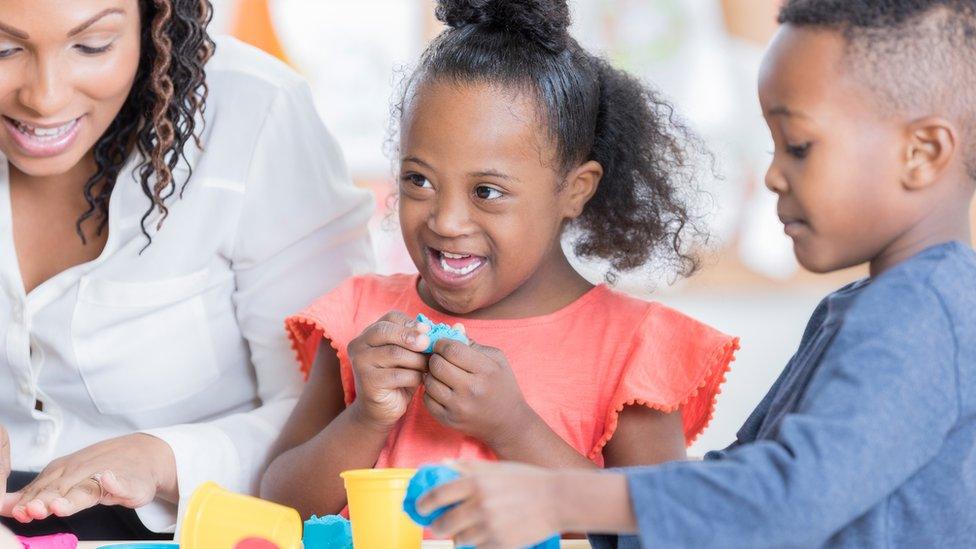 A girl with Down's syndrome playing.