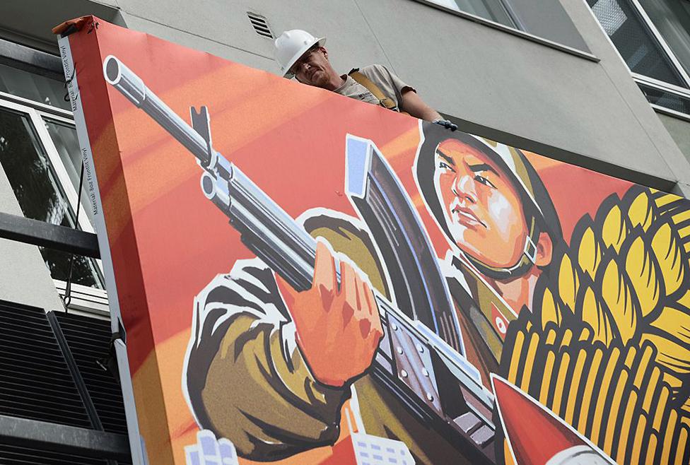 Workers remove a poster for "The Interview" from a billboard in Hollywood, California, December 18, 2014 a day after Sony announced was cancelling the movie's Christmas release due to a terrorist threat