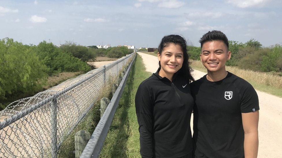 A young couple peers at the barrier