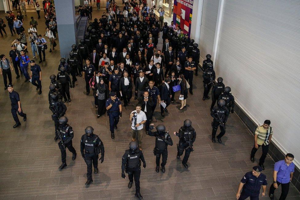 Siti Aisyah of Indonesia and Doan Thi Huong of Vietnam - who are on trial for the assassination of Kim Jong-nam, the estranged half-brother of North Korea"s leader Kim Jong-un - are escorted as they revisit scene of the attack at Kuala Lumpur International Airport 2 in Sepang, Malaysia, 24 October 2017.