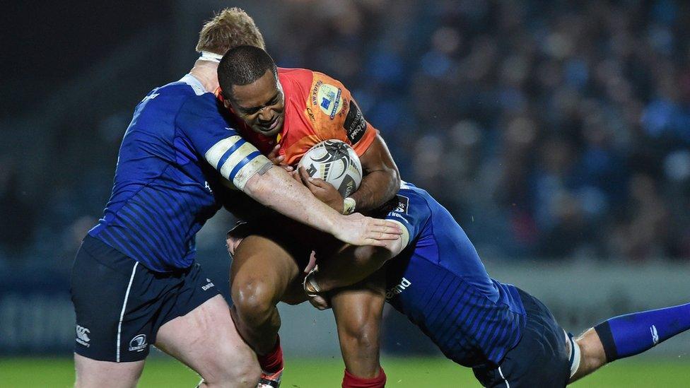 Michael Tagicakibau of Scarlets is tackled by James Tracy and Dominic Ryan