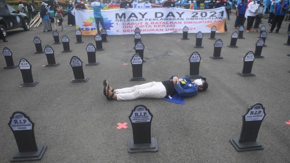 A member of an Indonesian labour organization lies down during a May Day rally