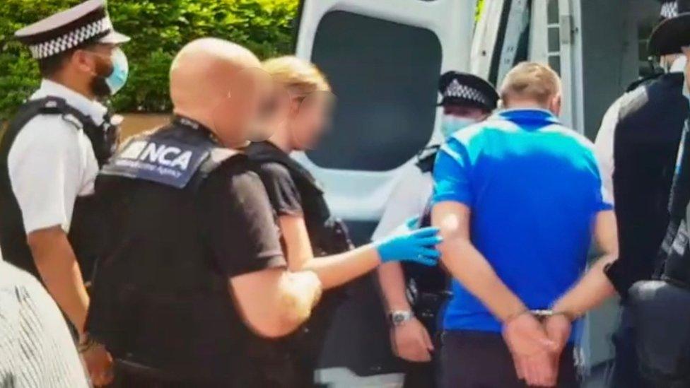 Officers detaining a 40-year-old man after conducting a raid on a property in Brighton Road, Purley, as part of a NCA operation aimed at dismantling an organised crime group involved in transporting hundreds of Albanian migrants to the UK illegally