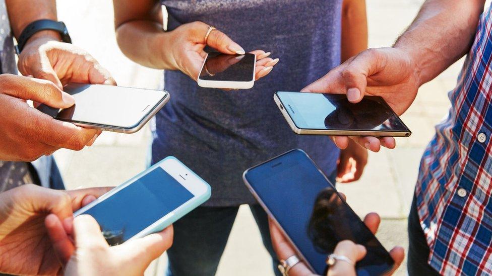 Shot of five smartphones in people's hands