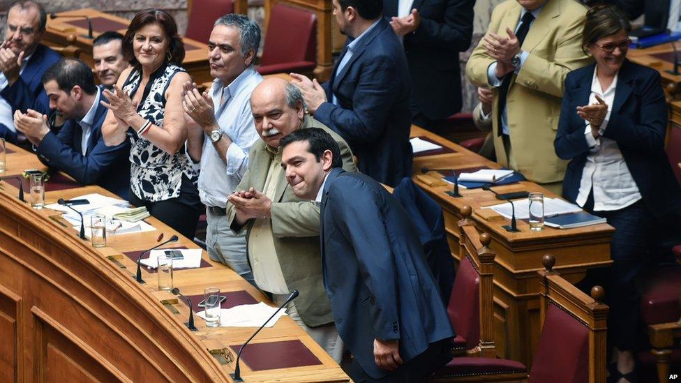 Members of the Greek Cabinet applaud as Greece's Prime Minister Alexis Tsipras arrives at parliament in Athens (9 July 2015)