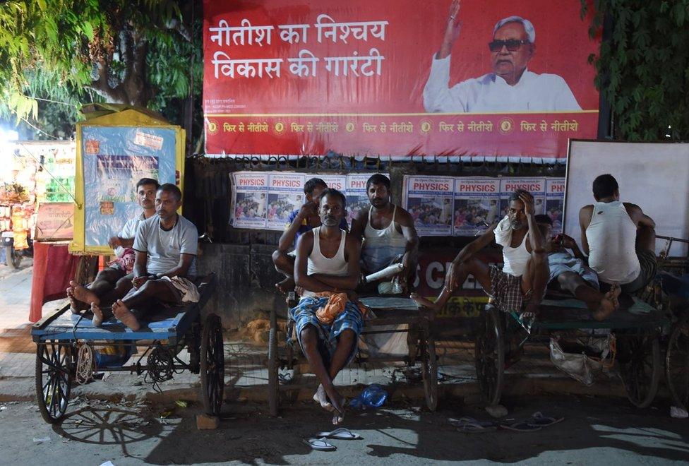 Indian workers sit on their handcarts on a street in Patna in the eastern state of Bihar.