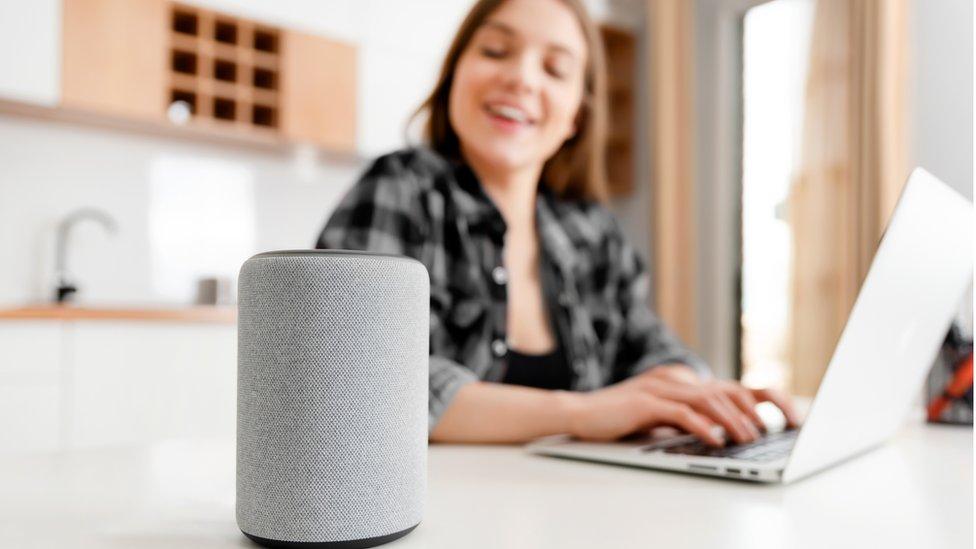 A woman looking at her voice assistant