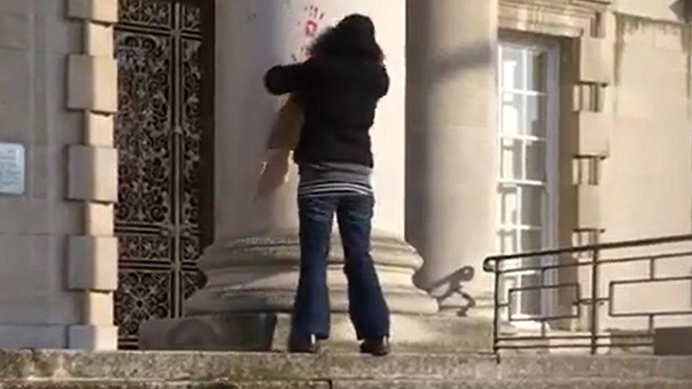 Woman makes handprints on stone columns