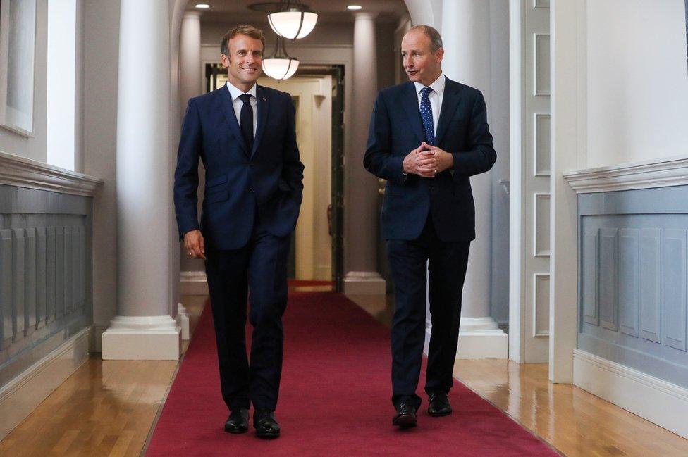 Emmanuel Macron and Micheál Martin walk along a corridor