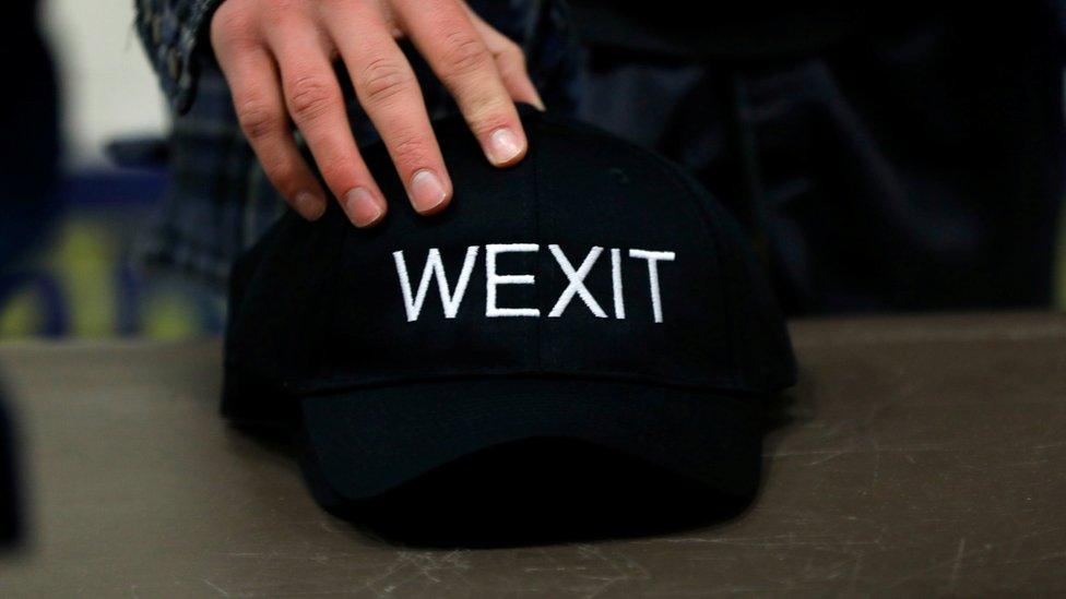 A supporter holds his Wexit hat while attending a rally for a separatist group seeking federal party status