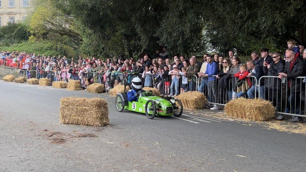 Spectators watching a green go kart