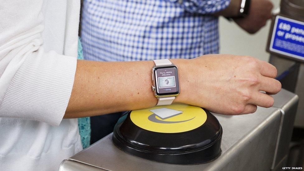 Someone touching an Apple Watch on to a contactless reader