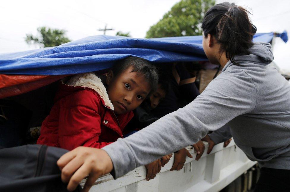 Filipino children shelter under a tarpaulin on a truck during evacuation in the town of Aparri, Cagayan province, Philippines, 19 October 2016