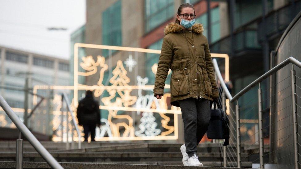 A person walks amongst festive lighting by the Bullring shopping centre in Birmingham