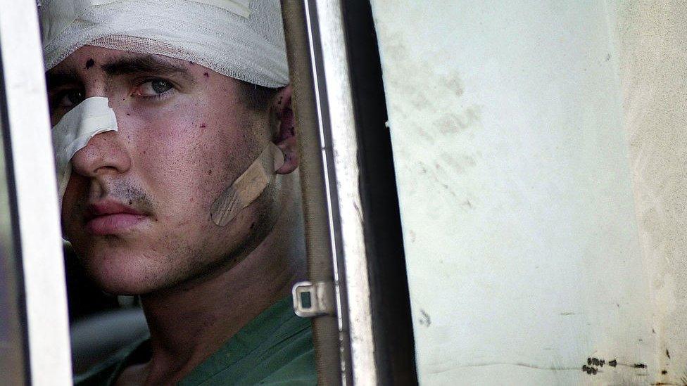 A wounded American sailor from the USS Cole being taken to a Yemeni hospital, 12 October 2000