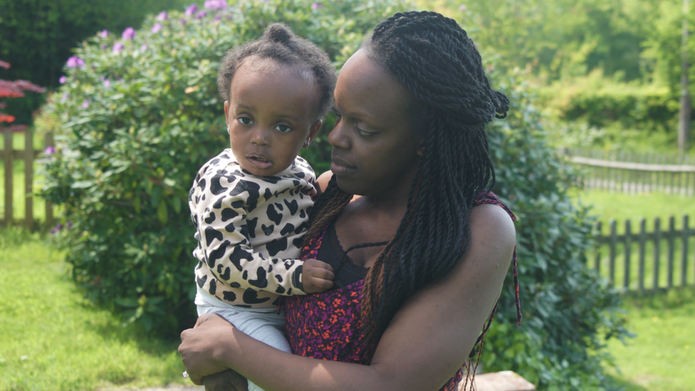 Tinu Alikor holding her daughter in a garden