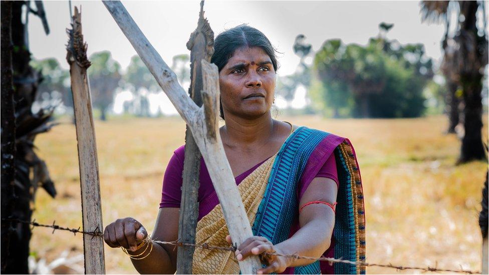 Jakakumari along a barbed fence wire at the field