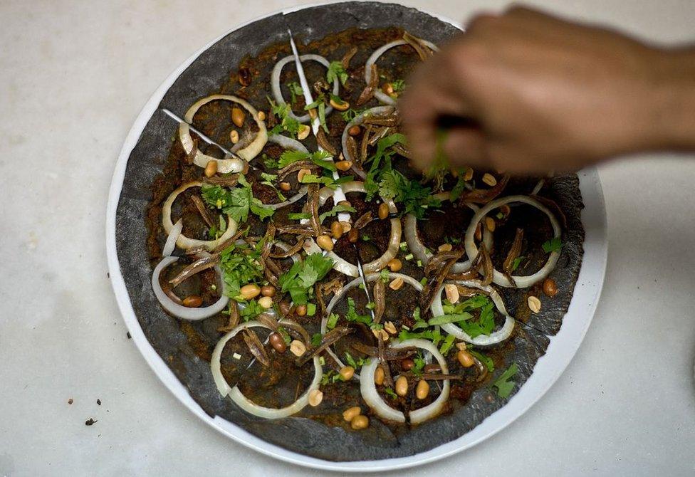 In this picture taken 6 April 2015 , a Malaysian chef gives final touches to the the Nasi Lemak pizza at the upscale Tujo Bar-serrie & Grill in Kuala Lumpur.