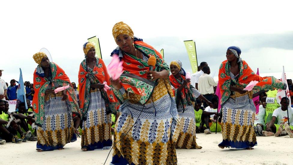 The cyclists finish at Vumawimbi beach with much fanfare. Here, women dance dressed in colourful kangas.