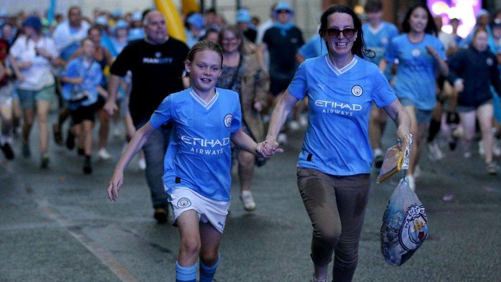 A young fan runs through the streets in the rain