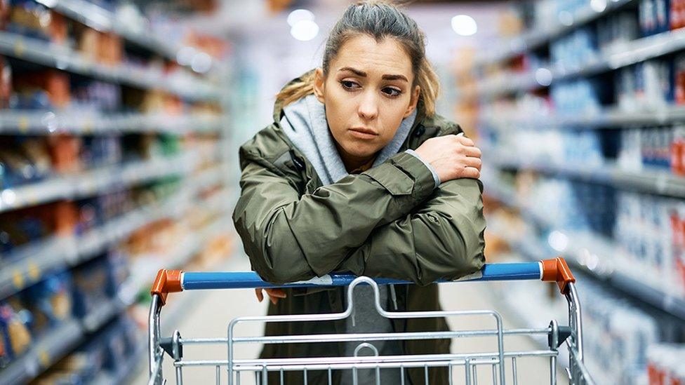 Woman leaning on trolley at supermarket