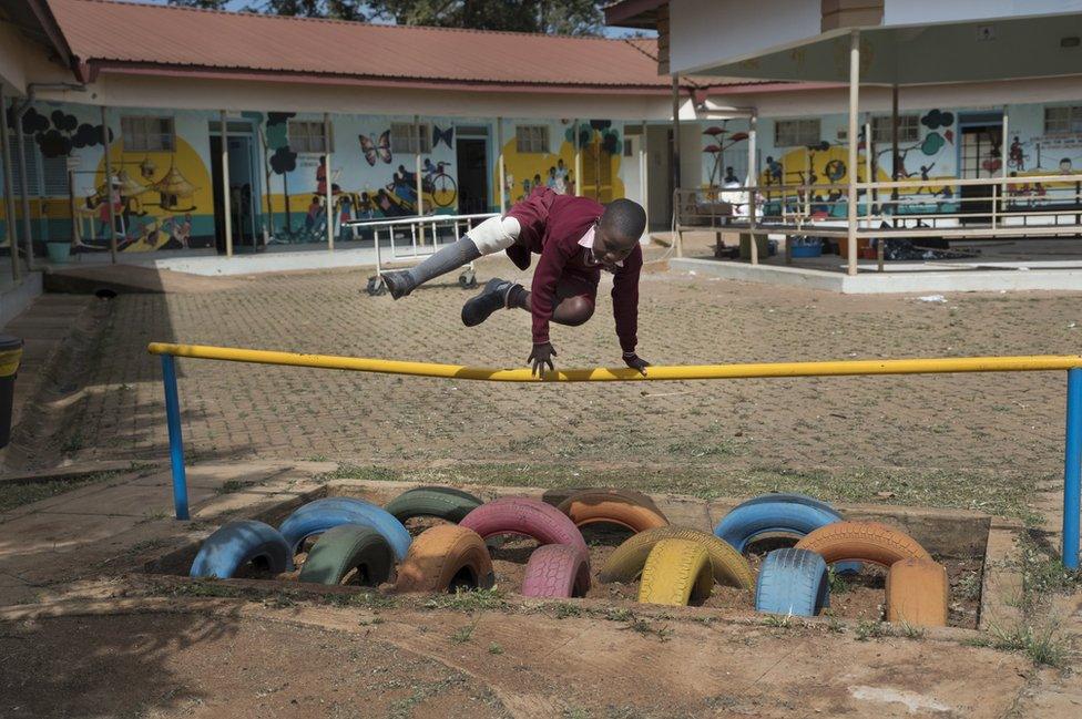 A boy jumps over a pole