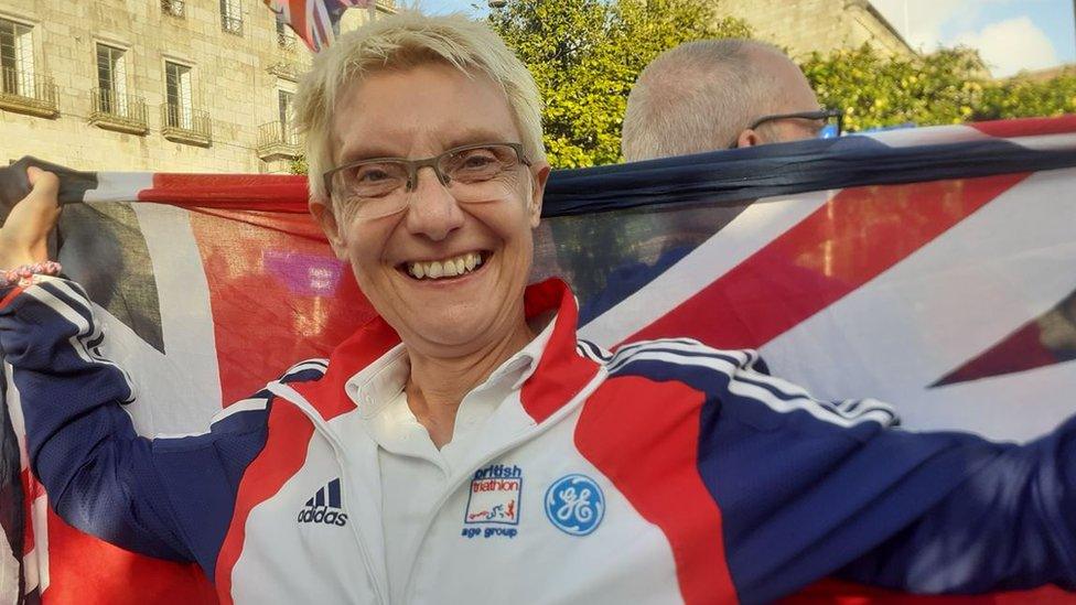 Ms Bown holding up a Great Britain flag and smiling