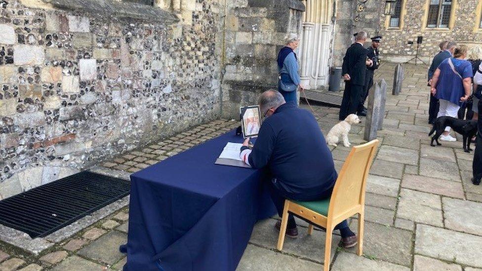 A resident signing a book of condolence in Winchester