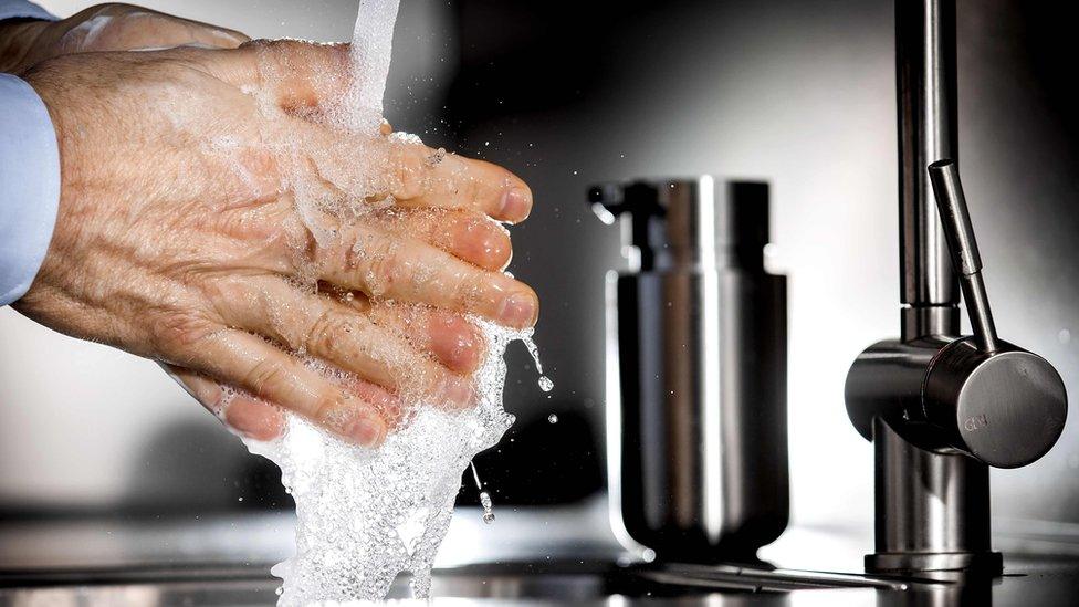 Washing hands under a tap