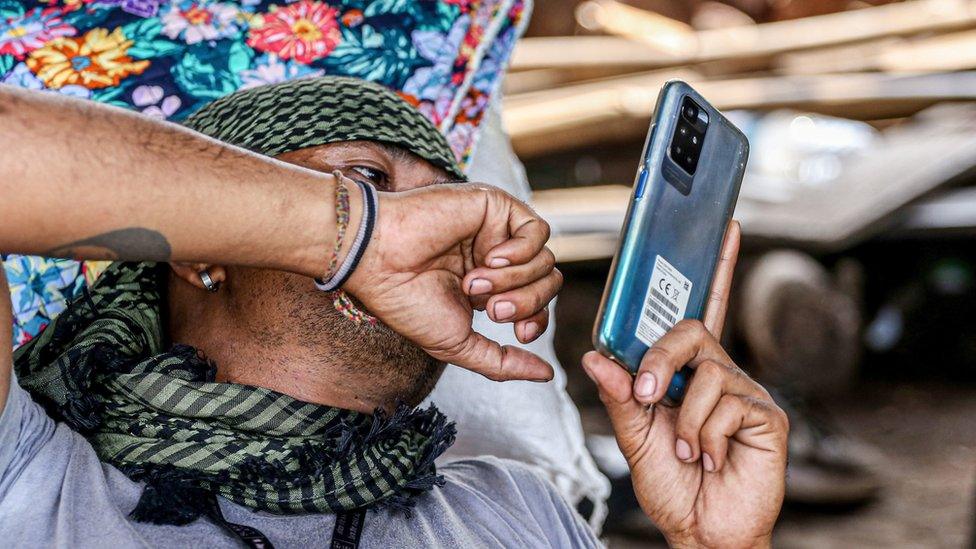 A member of the opposition uses his smartphone at base camp