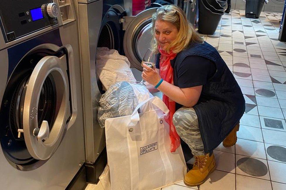 A customer at Laundry and Latte having a glass of wine while doing her laundry