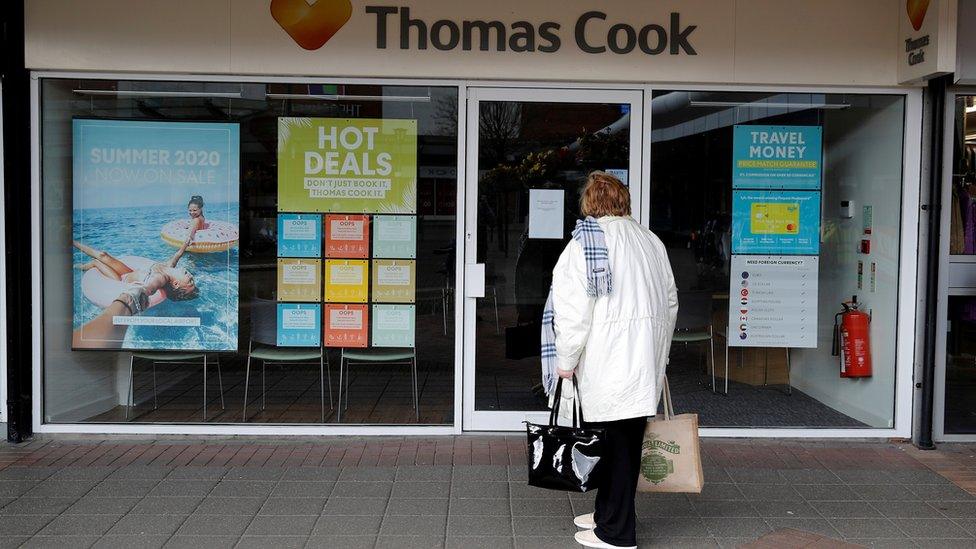 Woman walking into closed Thomas Cook