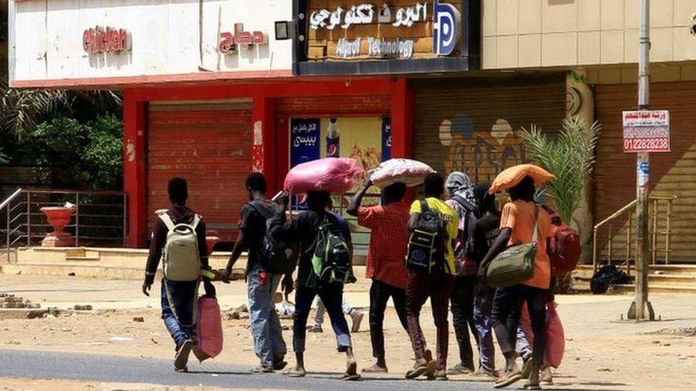 people carry belongings, khartoum 16 april