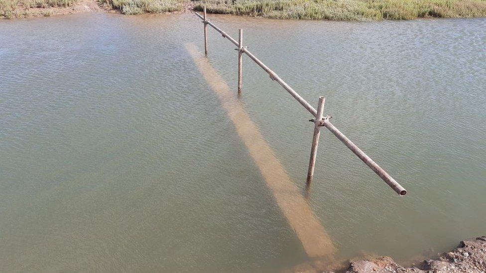 Makeshift wooden bridge at Stiffkey Marshes, with walkway submerged at high tide