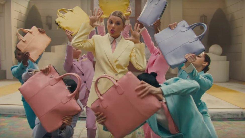 Taylor surrounded by handbags in Me! video