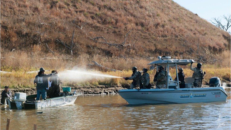 Police use pepper spray against protesters in a boat during a protest against the building of a pipeline on the Standing Rock Indian Reservation near Cannonball, North Dakota