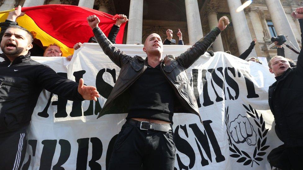Demonstrators disturb crowds at a makeshift memorial tribute to the victims of the Brussels terror attacks on Place de la Bourse square in Brussels 27/03/2016